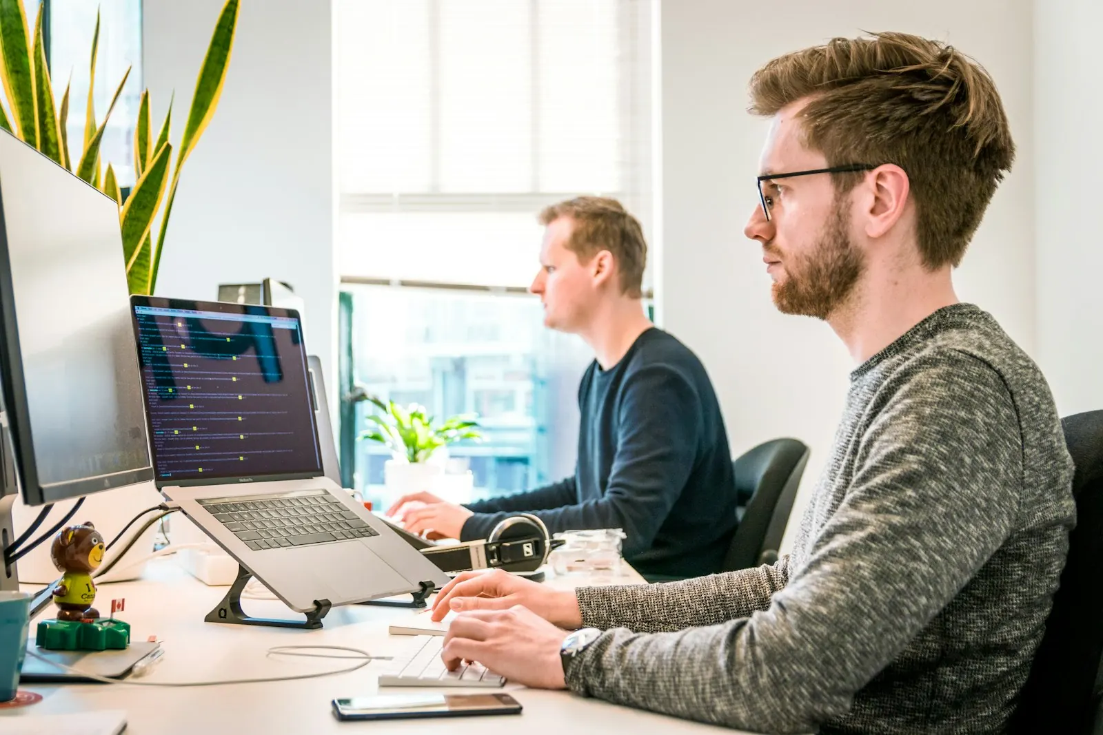 Duas pessoas trabalhando no computador em um escritório